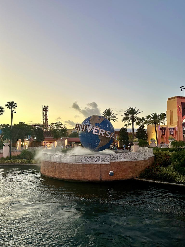 Iconic Universal Studios globe with fountain at sunset, Orlando theme park.